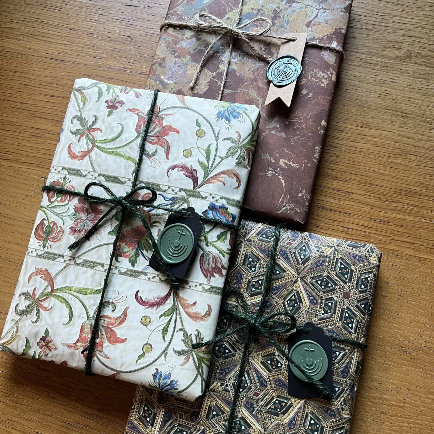 Four beautifully wrapped gifts with decorative paper, twine, and wax seals