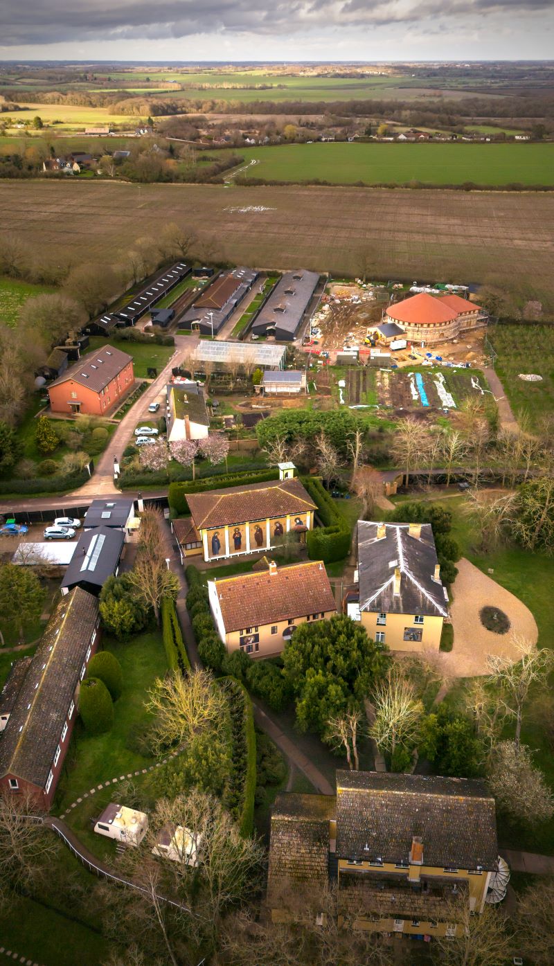 Aerial view of a rural property with farm buildings, houses, and fields.