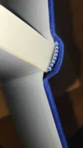 Close-up of a blue book binding with visible stitching on the spine.