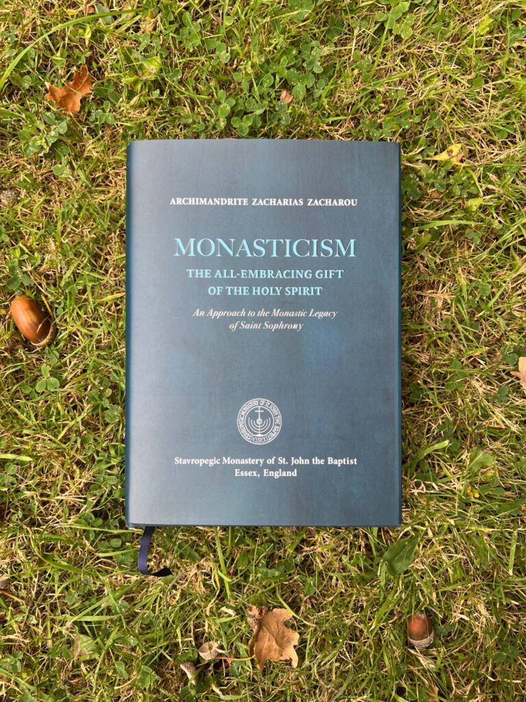 Archimandrite Zacharias Zacharou's book "Monasticism: The All-Embracing Gift of the Holy Spirit" on grass.