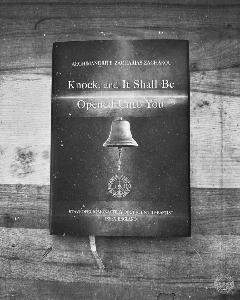 Archimandrite Zacharias Zacharou's book "Knock, and It Shall Be Opened Unto You" with a bell