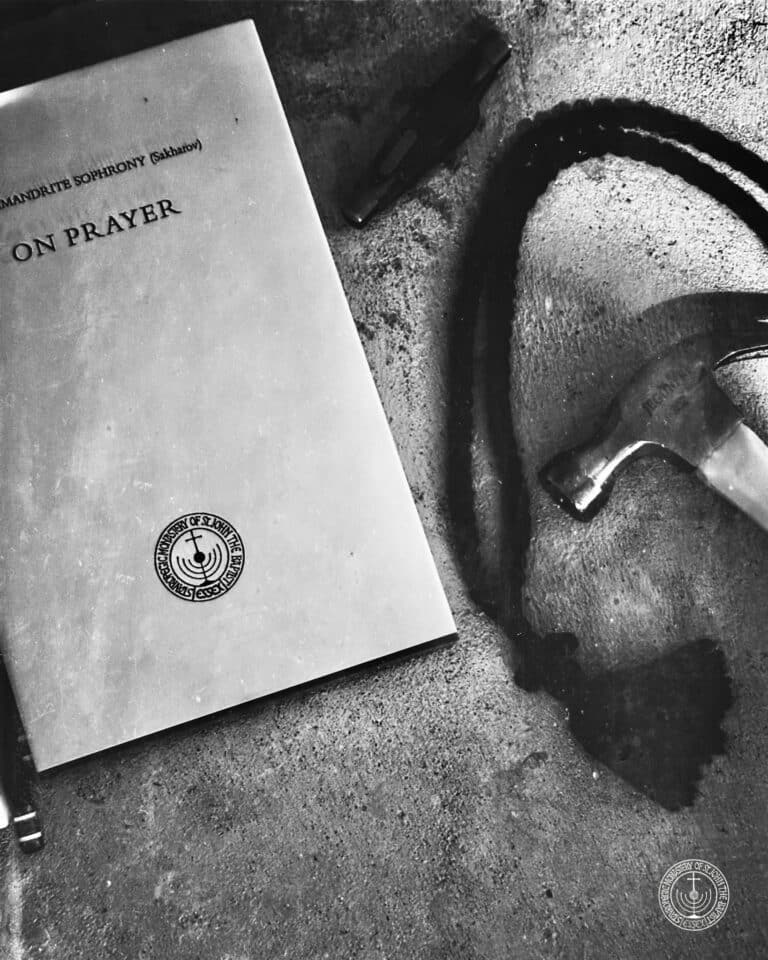 Archimandrite Sophrony's "On Prayer" book with a hammer and dark liquid