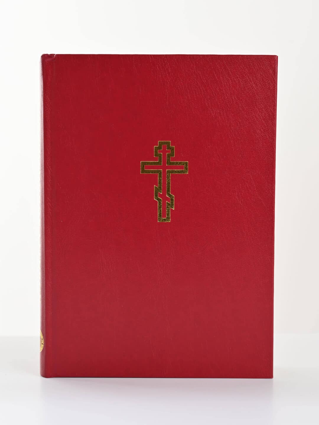 Red Orthodox Christian book with a gold cross emblem