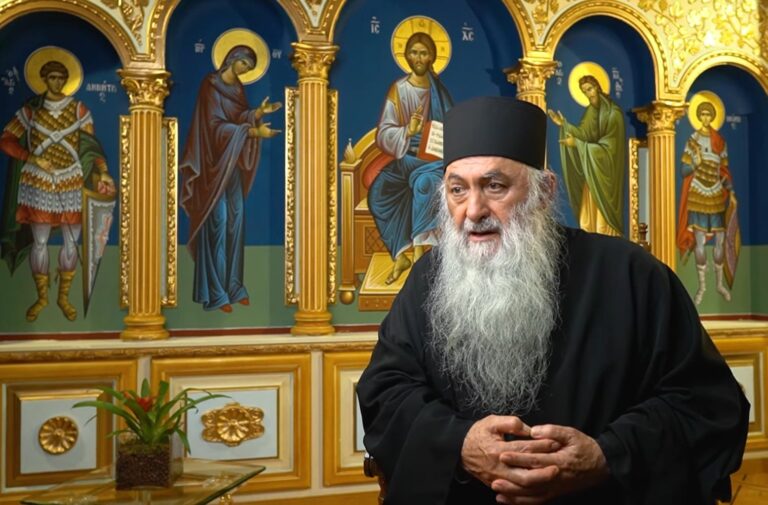 Orthodox priest with icons of saints in background
